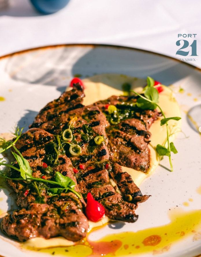 Grilled beef, sliced, on a creamy purée with herb oil